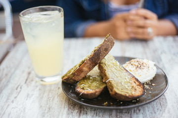 A plate of bruschetta and a glass of lemonade