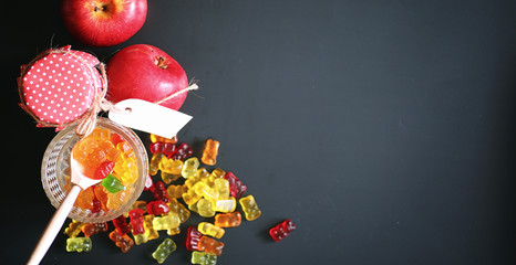 Marmalade in a vase on the table. Sweets in a bowl on a black ba