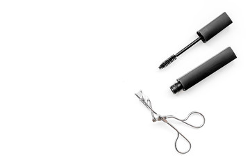 Basic products for eyelashes makeup. Mascara and eyelash curler on white background top view copy space