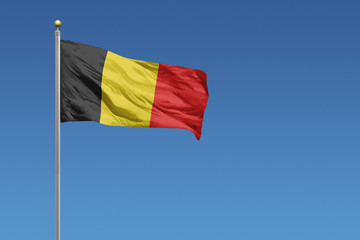 Belgium flag in front of a clear blue sky