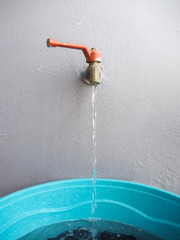 faucet and water flow on cloths in basin for hands washing.