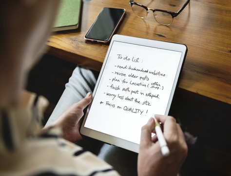 Caucasian Woman Writing To Do List On Tablet