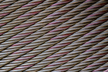 Closeup rough metal sling in tilted line pattern background.