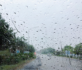 Heavy rain drop on the windows of car on the road.