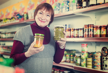 woman buyer  buying canned jar of peas