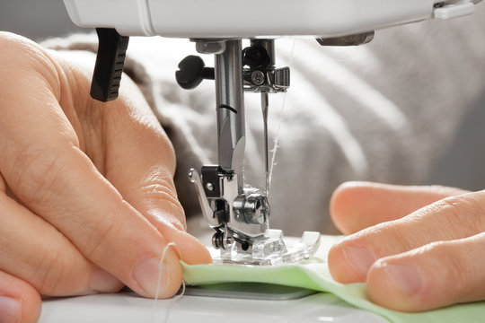 hands of seamstress working on the sewing machine