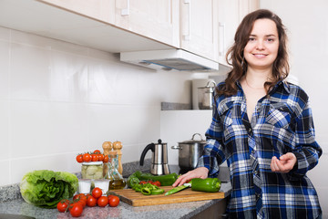 Obraz na płótnie Canvas Housewife cooking vegetables at kitchen