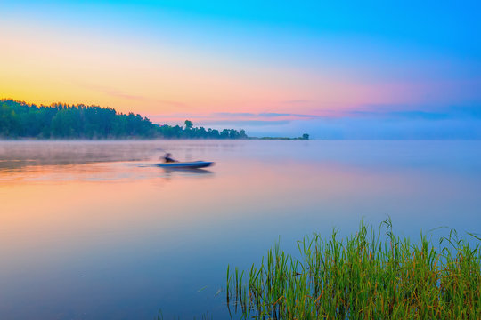 Red canoe on a lake at sunrise