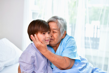 Patient Concept. Grandma's in the hospital. Waiting for someone to visit. Grandchildren visit grandma at the hospital. Grandma is happy to meet grandchildren.