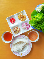 a suit of side dish of Thai rice flour noodles (called miang in thai language) on brown wooden desk