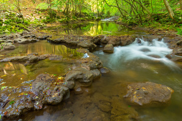 Pristine river and waterfalls in the mountains, in autumn