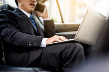 Attractive handsome young businessman using mobile smart phone in car