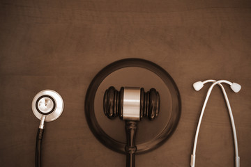 Fototapeta na wymiar Wooden gavel and stethoscope on wooden background with copyspace