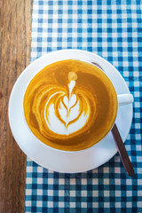 hot latte art coffee cup on wooden table
