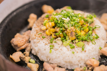 Chicken pepper with rice on hot plate on top with corn