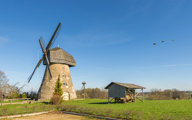 Fototapeta na wymiar Countryside landscape with windmill in early springtime, Europe