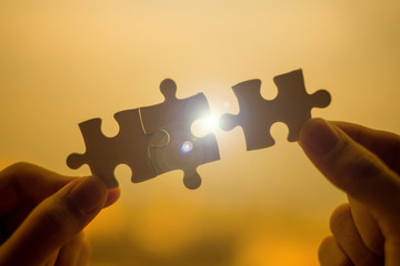 Silhouette Woman hands connecting couple puzzle piece against sunrise effect, businesswoman holding...