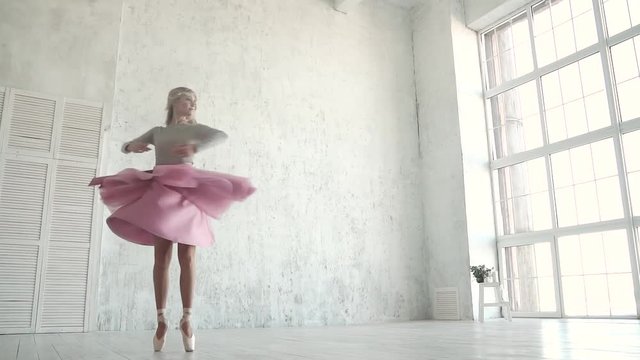 dancer of the ballet is spinning against the background of a large light window. ballerina in a classic tutu and pointe. slow motion