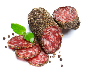 Dried organic salami sausage covered with pepper on white background