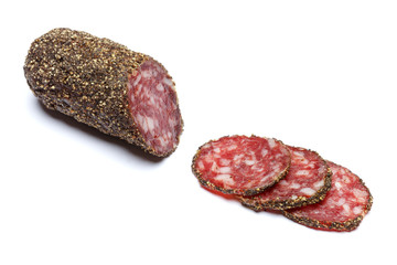 Dried organic salami sausage covered with pepper on white background