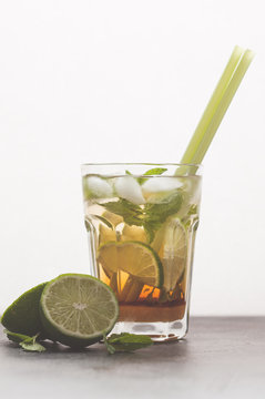 Brazilian traditional caipirinha with lime, sugar and mint. White background, dark table, copy space.