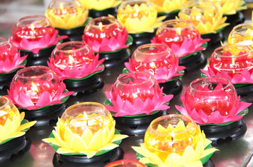 Burning candles in candlesticks in the form of a lotus