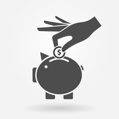 Hand putting money coin into piggy bank. Savings and banking icon concept