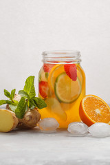 Ginger fruity ice tea with mint in a glass jar, white background, copy space. Summer refreshing drink concept.