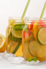 Fruit and ginger green ice tea with mint in a glass jar, white background, copy space. Summer refreshing drink concept.