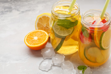 Fruit ice tea and ginger herbal ice tea with mint in a glass jars, white background, copy space. Summer refreshing drink concept.