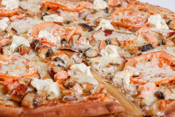 Italian kitchen and cooking concept. Hot tasty sliced with salmon, eel, seafood, tomato. Eat delivery concept.