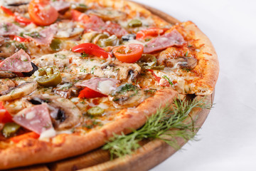 Italian kitchen and cooking concept. Hot tasty sliced with ham, sausage, jalapenos, mushrooms, tomato. Eat delivery concept.