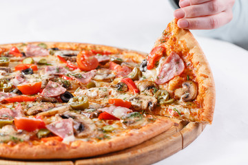 Italian kitchen and cooking concept. Hot tasty sliced with ham, sausage, jalapenos, mushrooms, tomato. Eat delivery concept.