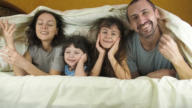Family under the blanket. Happy family in the bedroom.