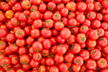 Clean eating concept. Bunch of ripe juicy freshly picked organic cherry tomatoes in pile at local produce farmers market. Healthy diet for spring summer detox. Vegan raw food. Close up, background.