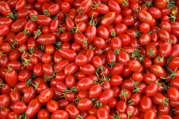 Clean eating concept. Bunch of ripe juicy freshly picked organic cherry tomatoes in pile at local produce farmers market. Healthy diet for spring summer detox. Vegan raw food. Close up, background.