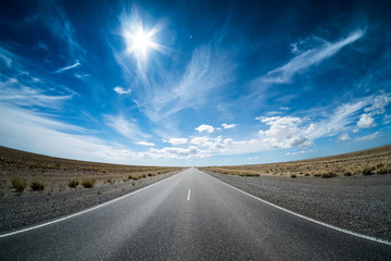 Asphalt road in the desert and sky with clouds. Road 3 (Ruta 3) through the Argentinean pampa.