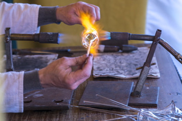 Artesania del vidrio habil y perfecta   trabajando con soplete en una feria medieval popular a la...