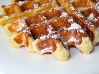 Belgian waffles with icing sugar isolated on white