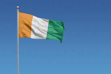 Naklejka na ściany i meble Ivory Coast Flag of in front of a clear blue sky