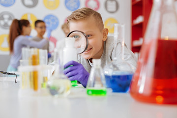 Young researcher. Charming teenage male student studying a chemical reaction in the chemical lab...