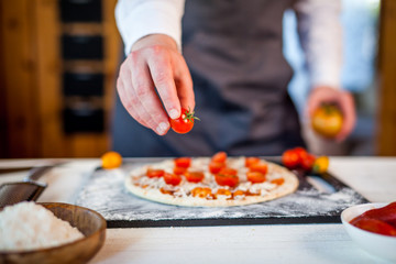 closeup hands of chef making fresh homemade traditional italian pizza. wallpaper for pizzeria and cooking food concept