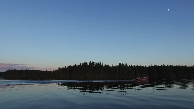 Motorboat sailing on lake at dusk 