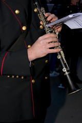 Obraz na płótnie Canvas Horizontal View of Close Up of Musician Playing Clarinet in Black Uniform. Taranto, South of Italy
