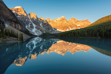 Moraine Lake, Canada. Beautiful sunrise under the Moraine lake with snow-covered peaks above it in Canadian Rockies,  Banff National Park.