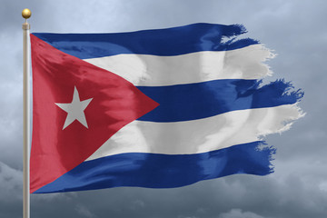 Cuba Flag with torn edges in front of a stormy sky