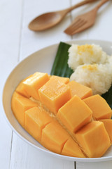 Mango and sticky rice in white dish on white wooden floor and have copy space.