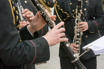 Fototapeta na wymiar Horizontal View of Close Up of Musicians Playing Clarinet in Black Uniform. Taranto, South of Italy