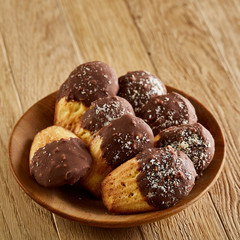 Freshly baked almond cookies piled on ceramic plate over rustic background, top view, close-up, selective focus