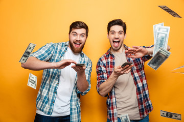 Portrait of a two happy young men scattering money - obrazy, fototapety, plakaty